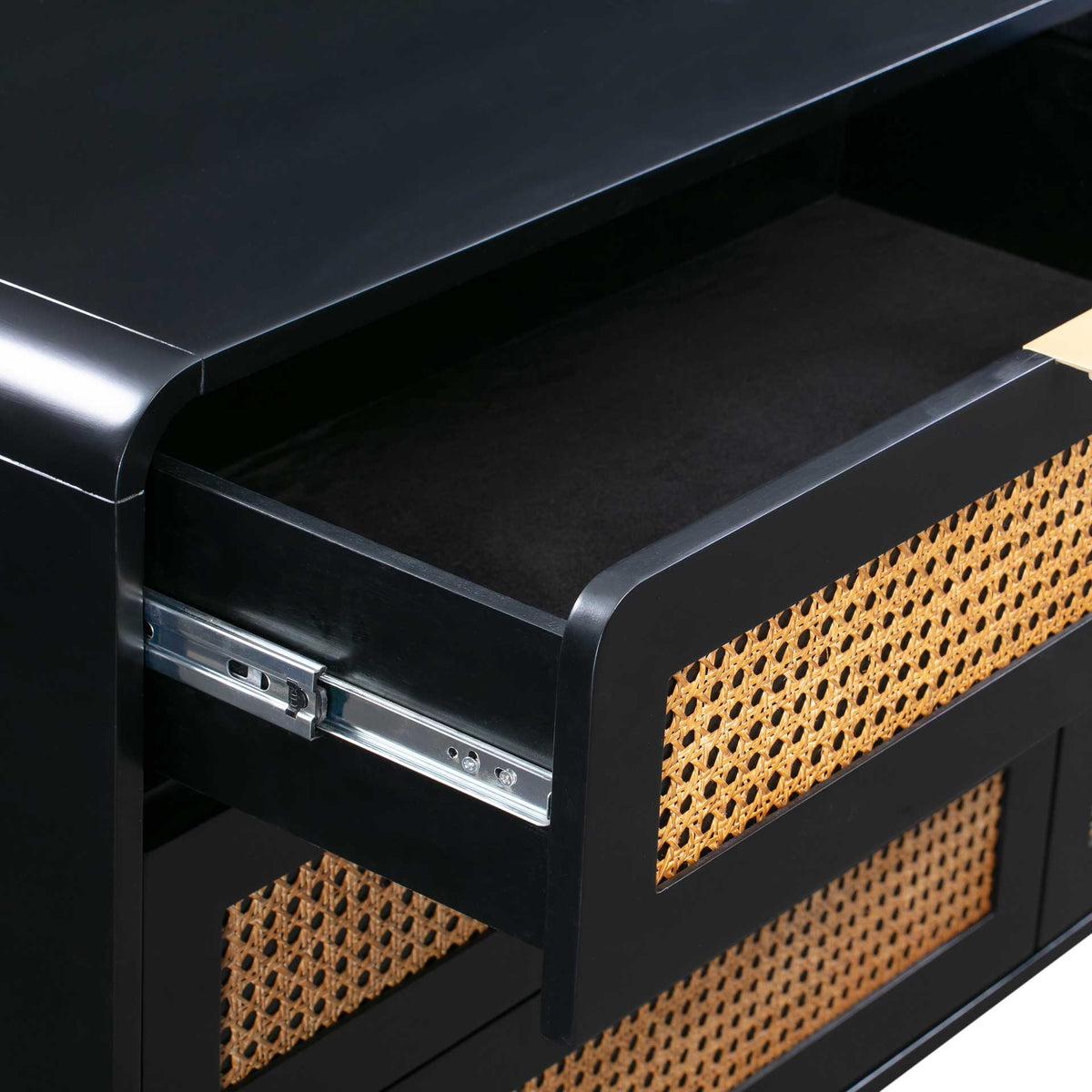 An open drawer reveals a roomy black interior, metal slides, and a natural cane front