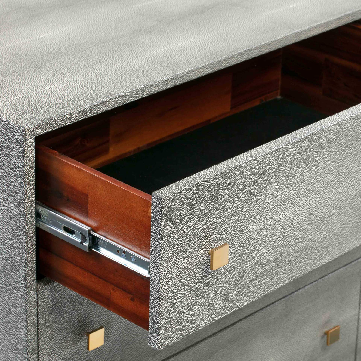 Warm wood drawer sides and metal glides complement the dresser's textured gray exterior
