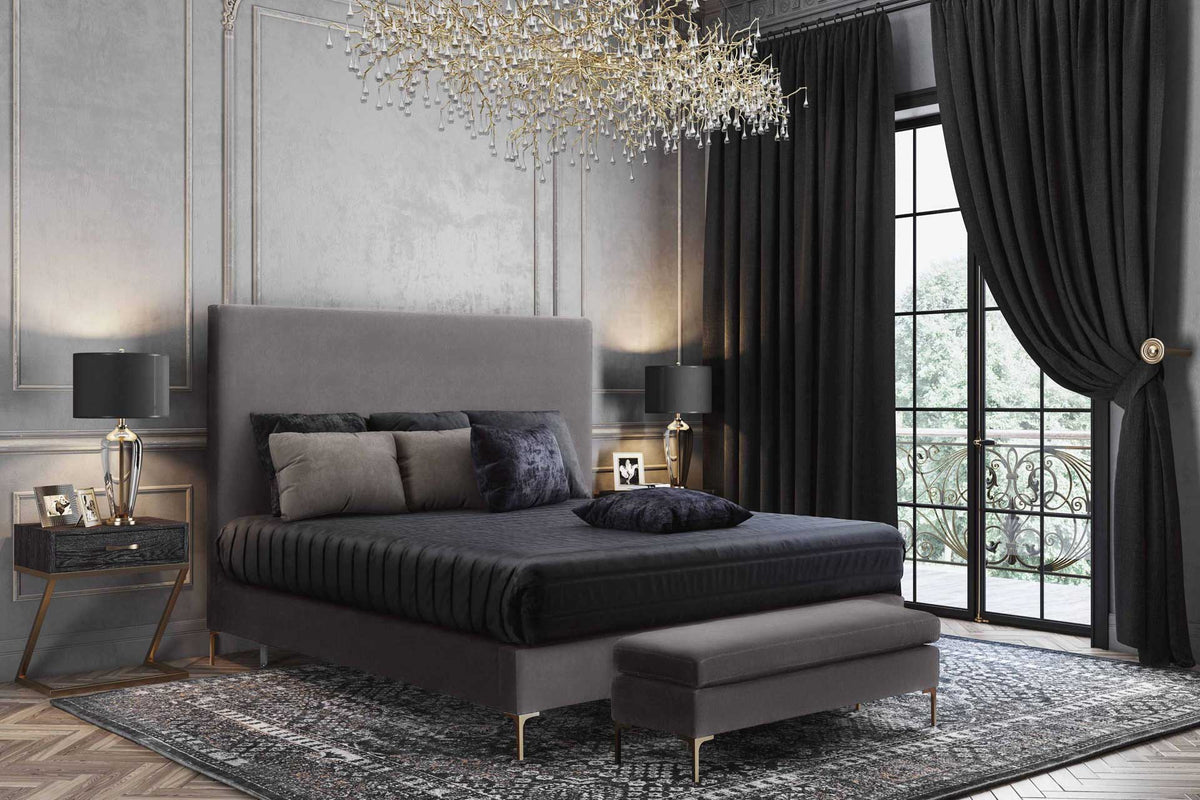 A tall gray velvet headboard and slim gold legs bring refined elegance to a richly layered bedroom.