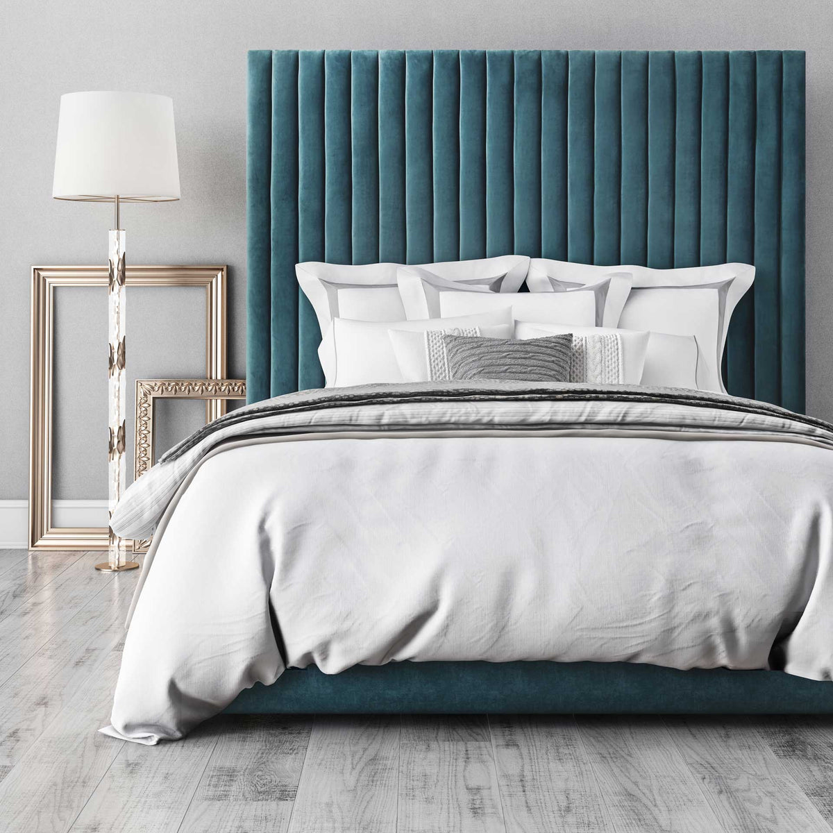 A rich blue velvet headboard creates a textured backdrop for crisp white bedding and layered pillows