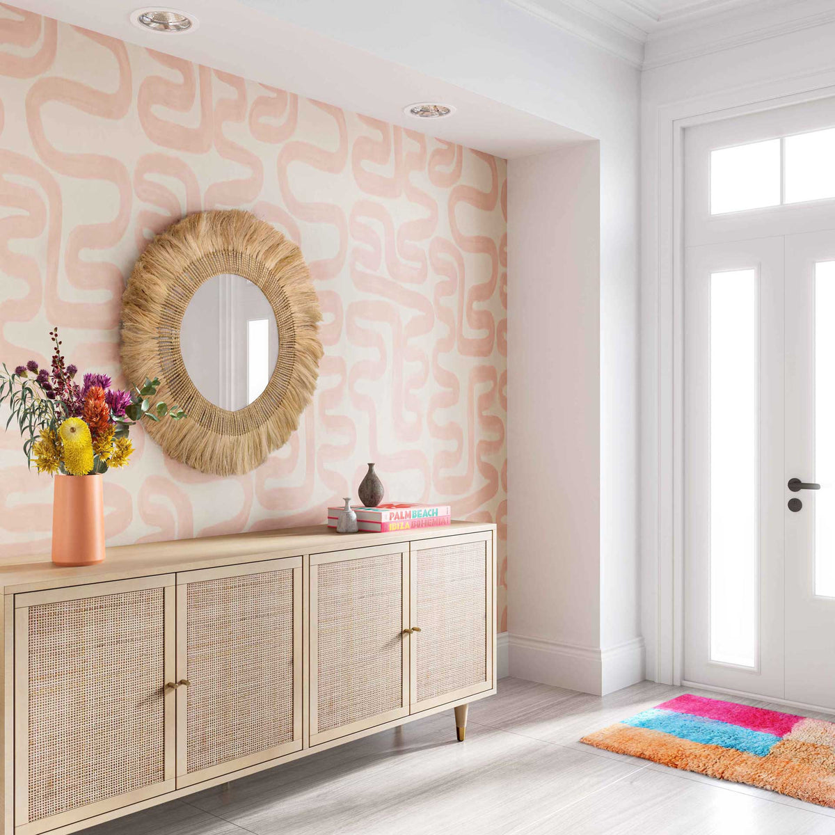A fringed round mirror adds natural warmth and woven texture to an entryway
