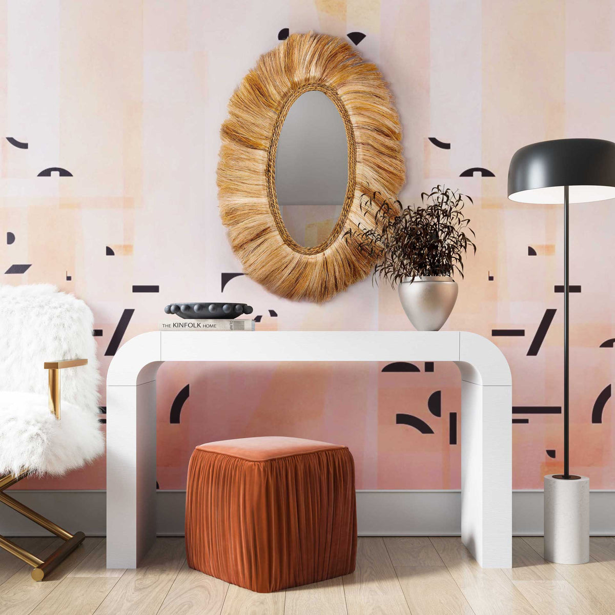 A fringed oval mirror adds warmth and organic texture above a sleek white console.