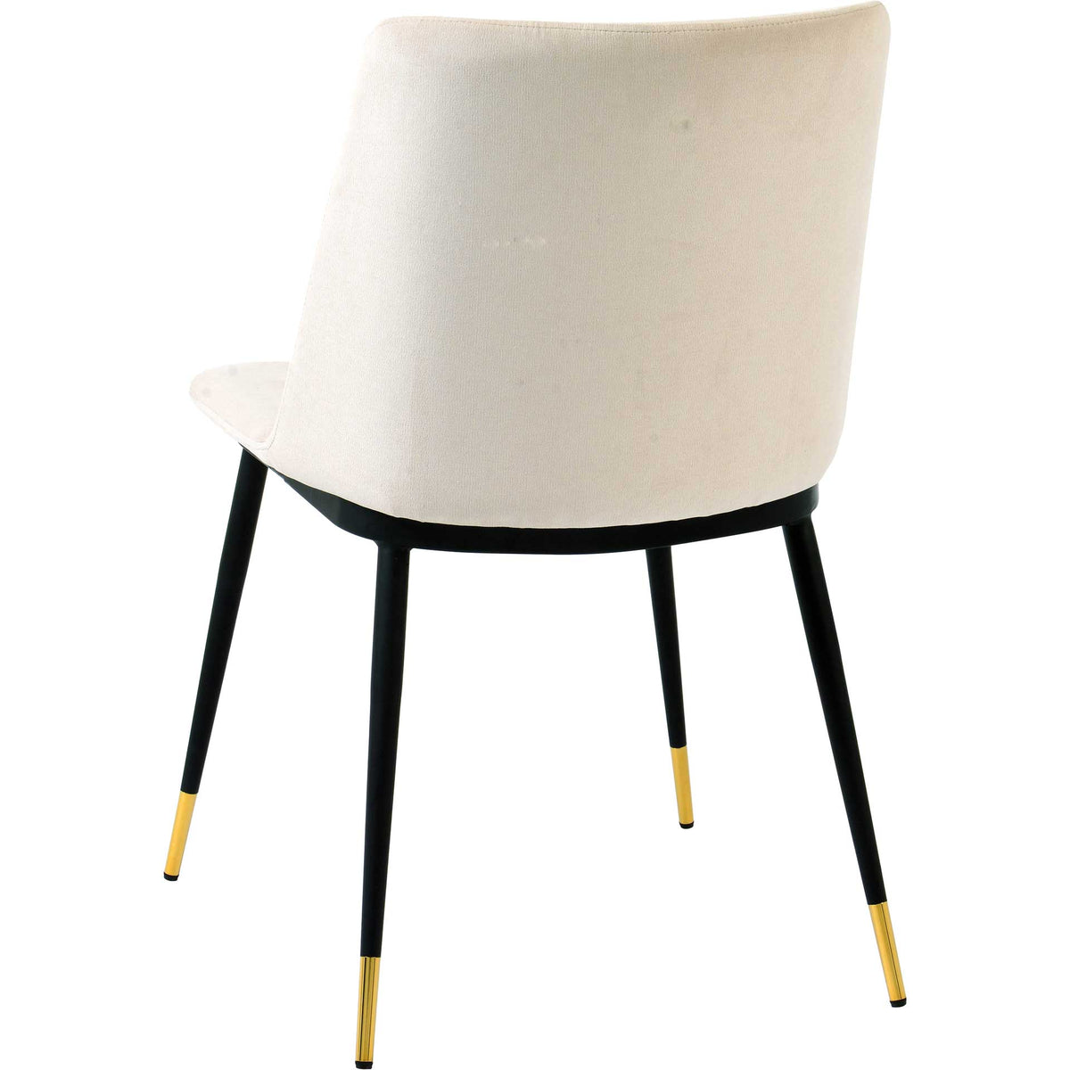 Cream velvet covers the curved back, while splayed black legs end in polished gold accents.