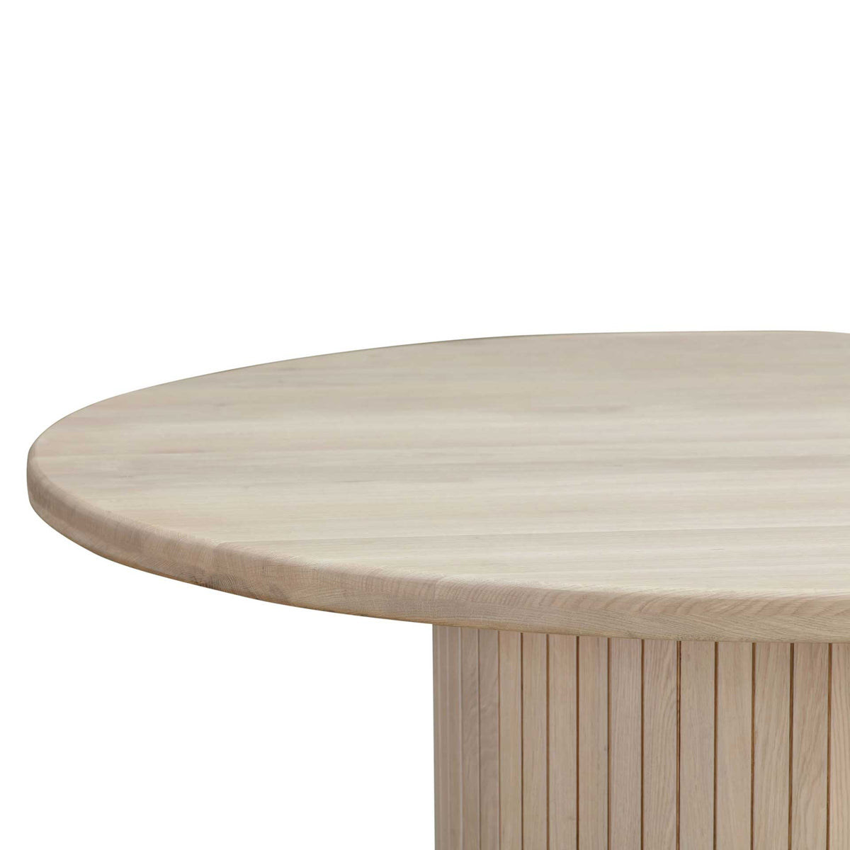 A softly rounded tabletop edge highlights pale oak grain and the generous overhang above the pedestal.