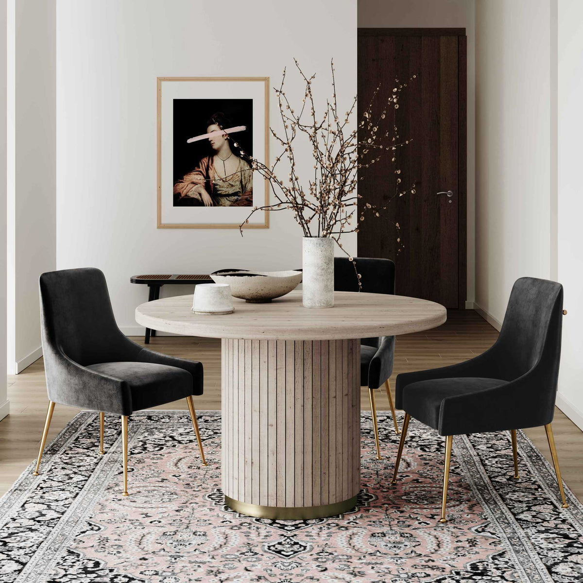 A round oak table with a textured pedestal and brass-tone trim adds warmth beside dark upholstered chairs.