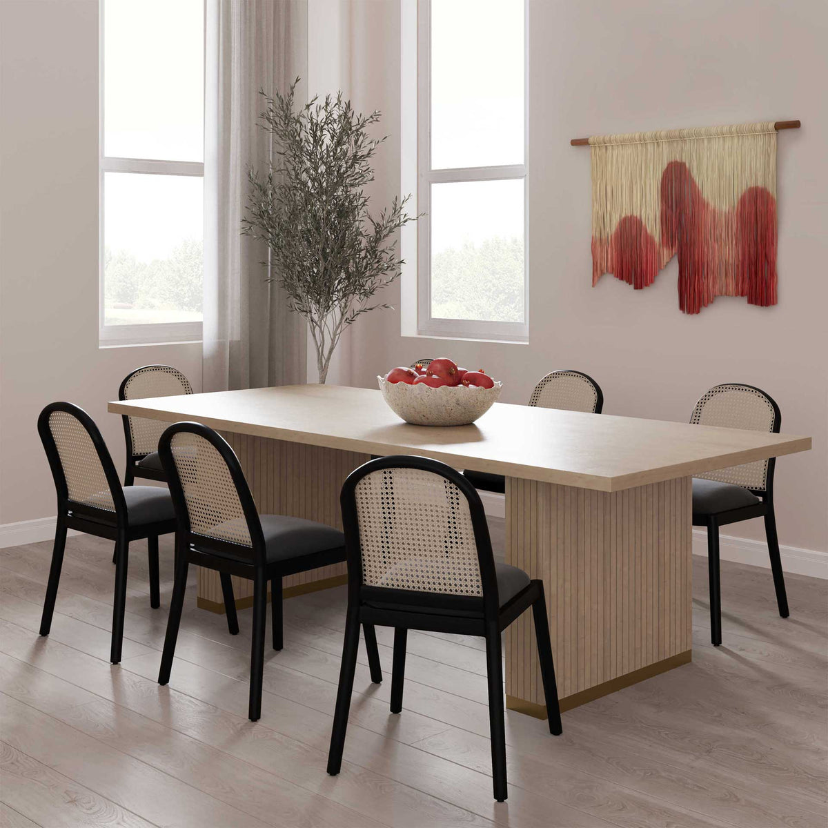 A long natural oak table creates an inviting gathering place alongside black woven-back dining chairs.