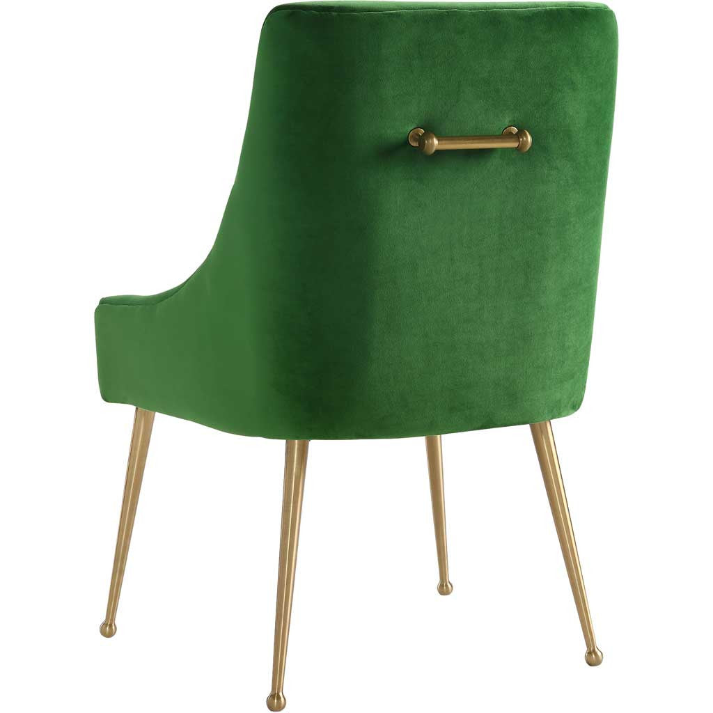 Rich green velvet wraps the chair's curved shell, accented by a gold handle and tapered gold legs.