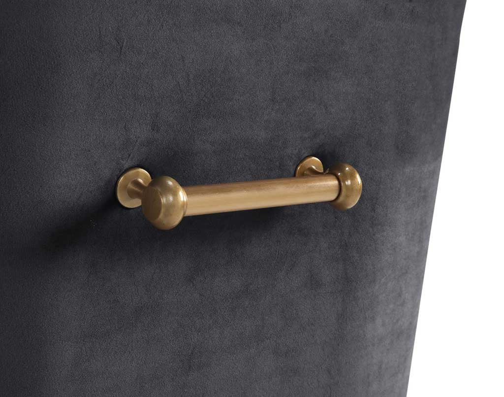 A cylindrical gold handle with rounded ends adds a warm metallic accent to charcoal gray velvet.