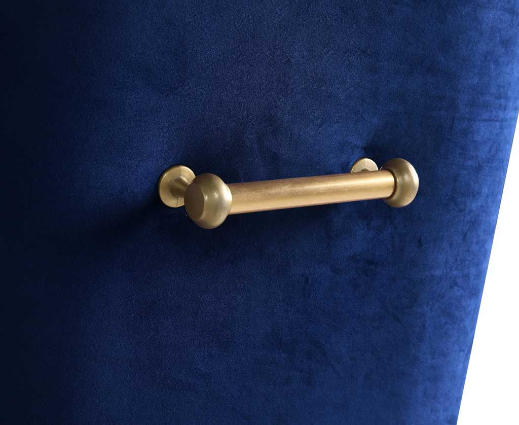 A sleek gold bar handle with rounded ends brings a polished finishing touch to rich navy velvet.