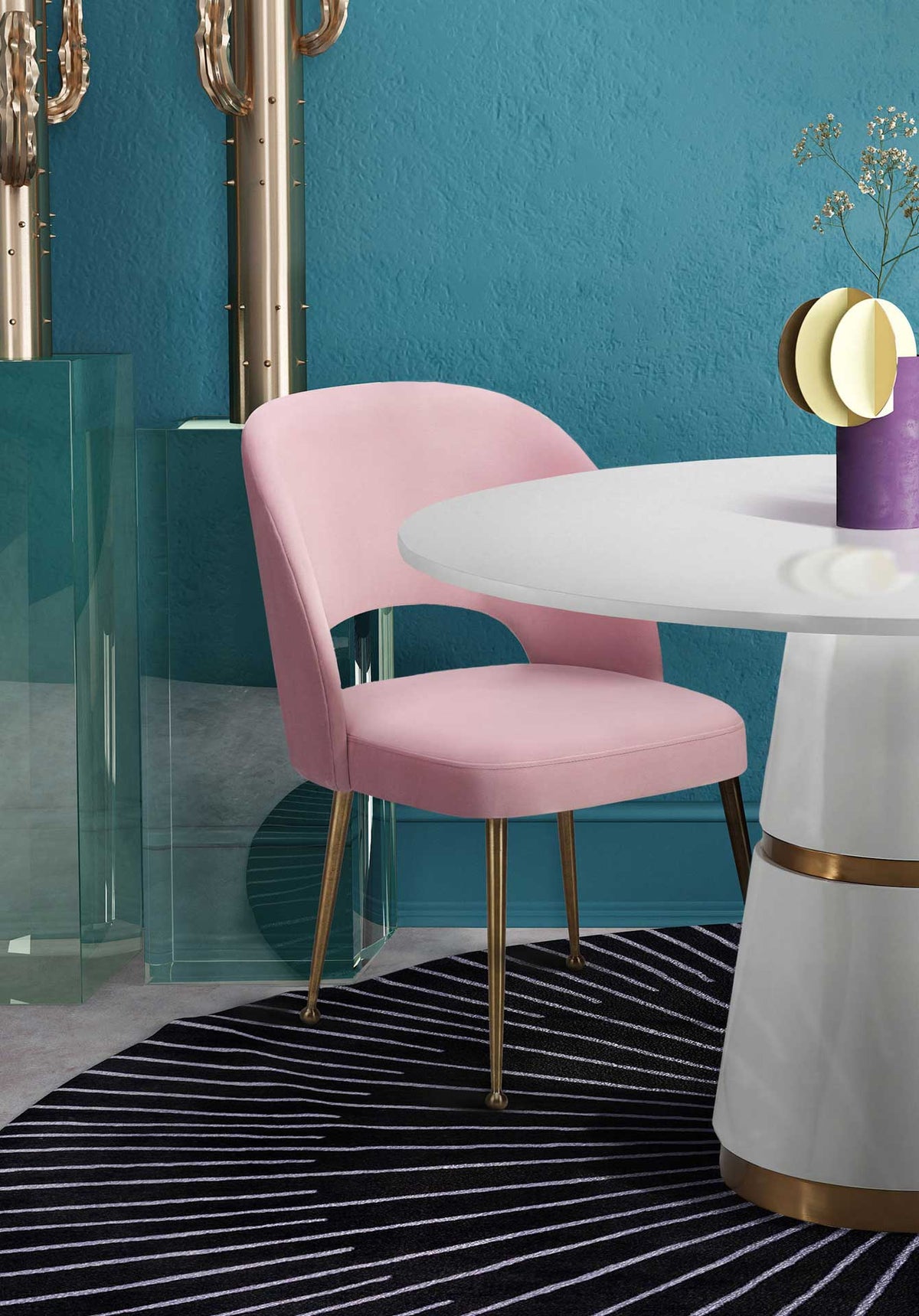 Plush pink velvet and slender gold legs add a warm accent beside a white pedestal table