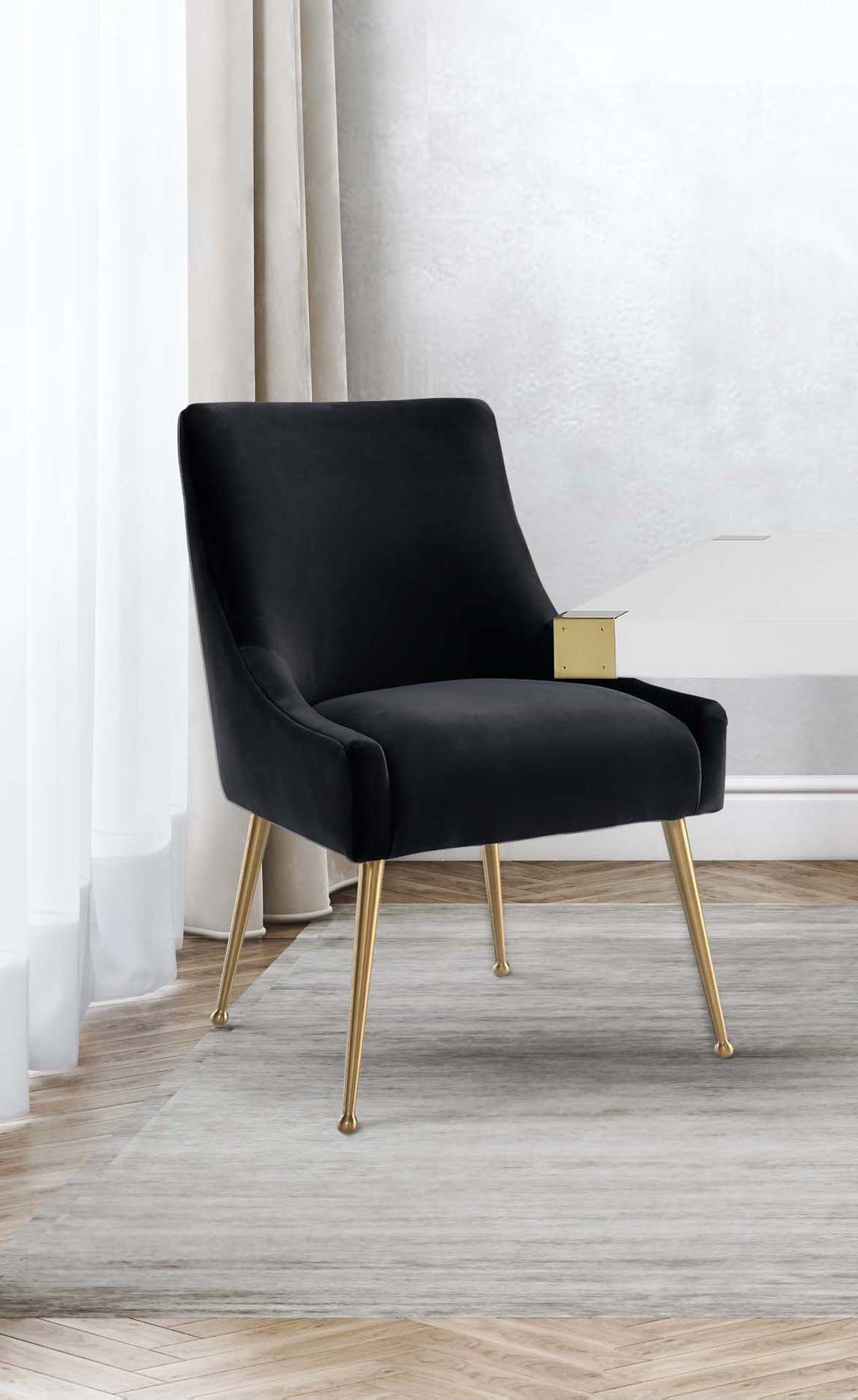 Black velvet upholstery and slim gold legs create a crisp contrast beside a white tabletop.