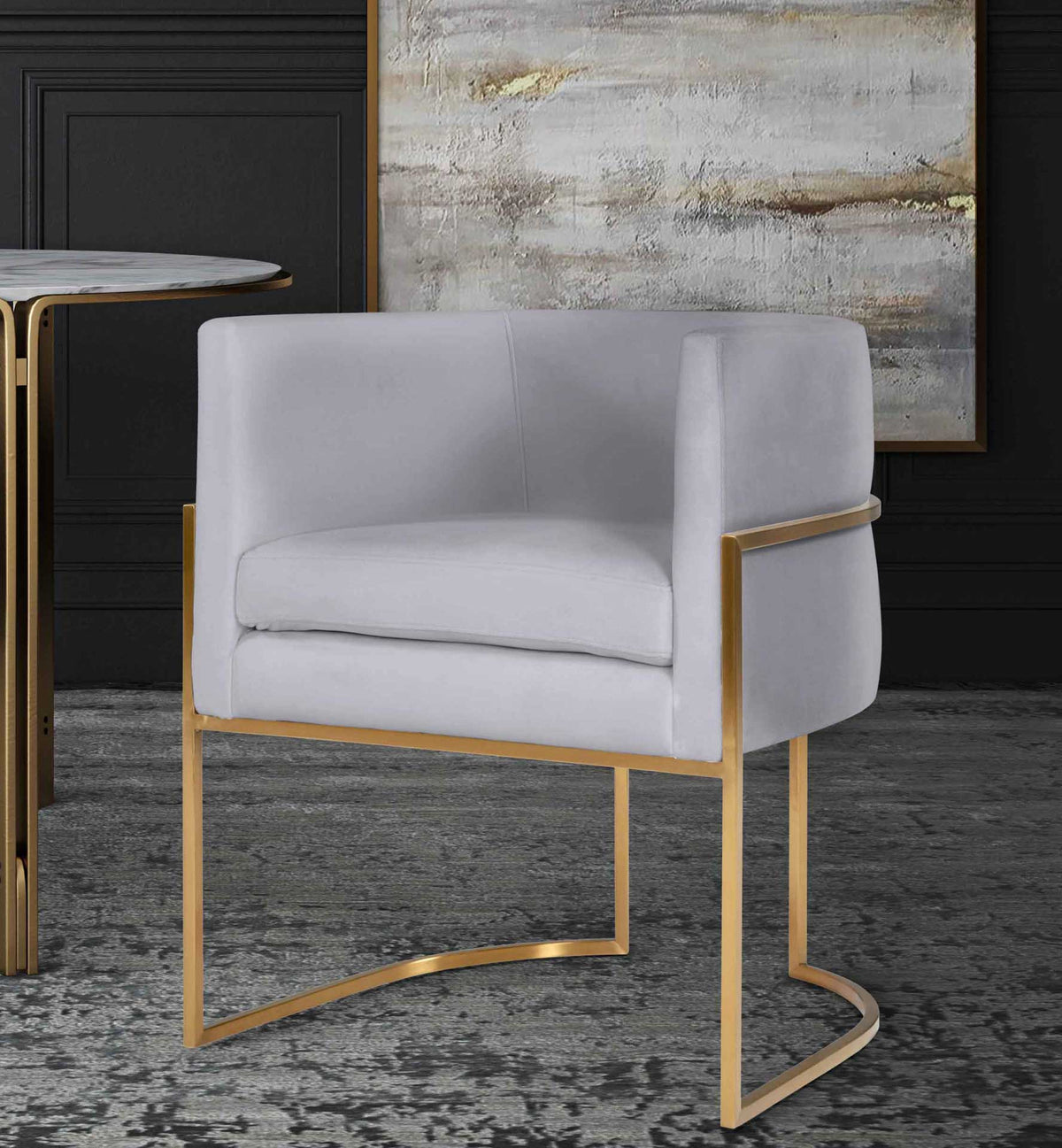 Gray velvet and a warm gold frame add refined texture and sculptural style to a modern dining space