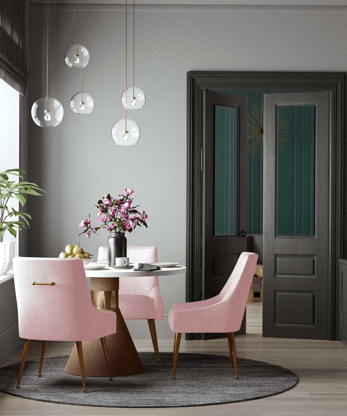 Blush velvet chairs with pleated backs and gold accents soften a round pedestal dining table.