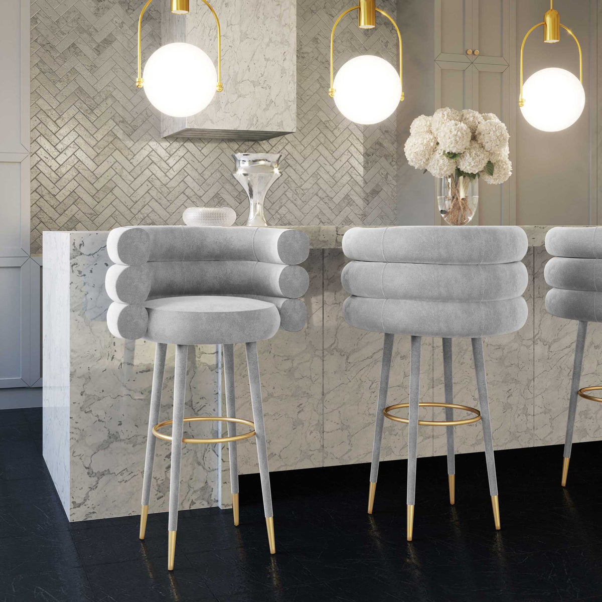 Gray velvet barstools bring plush curves and warm gold accents to kitchen island seating