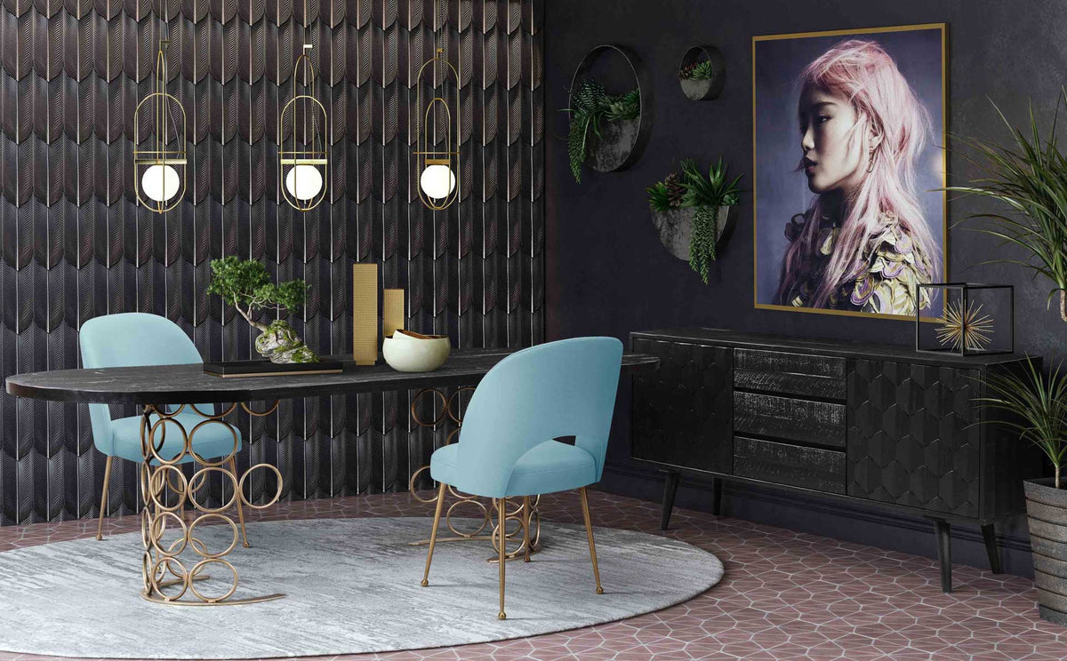 Sea blue velvet chairs add a soft pop of color to a dramatic black and gold dining space