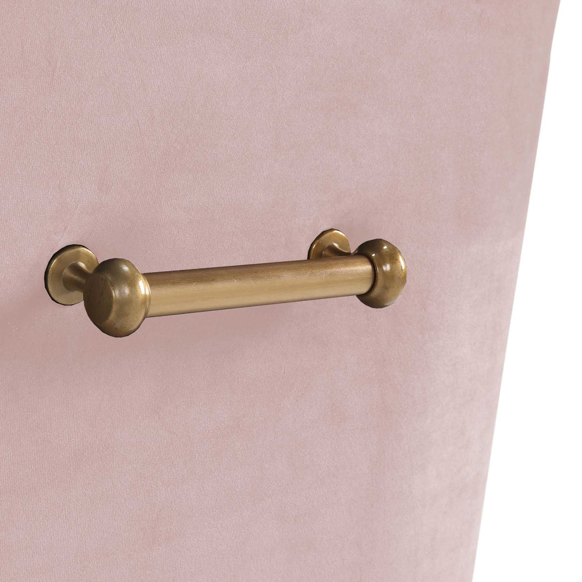 A rounded gold pull adds a jewelry-like accent to the chair's soft blush velvet upholstery.