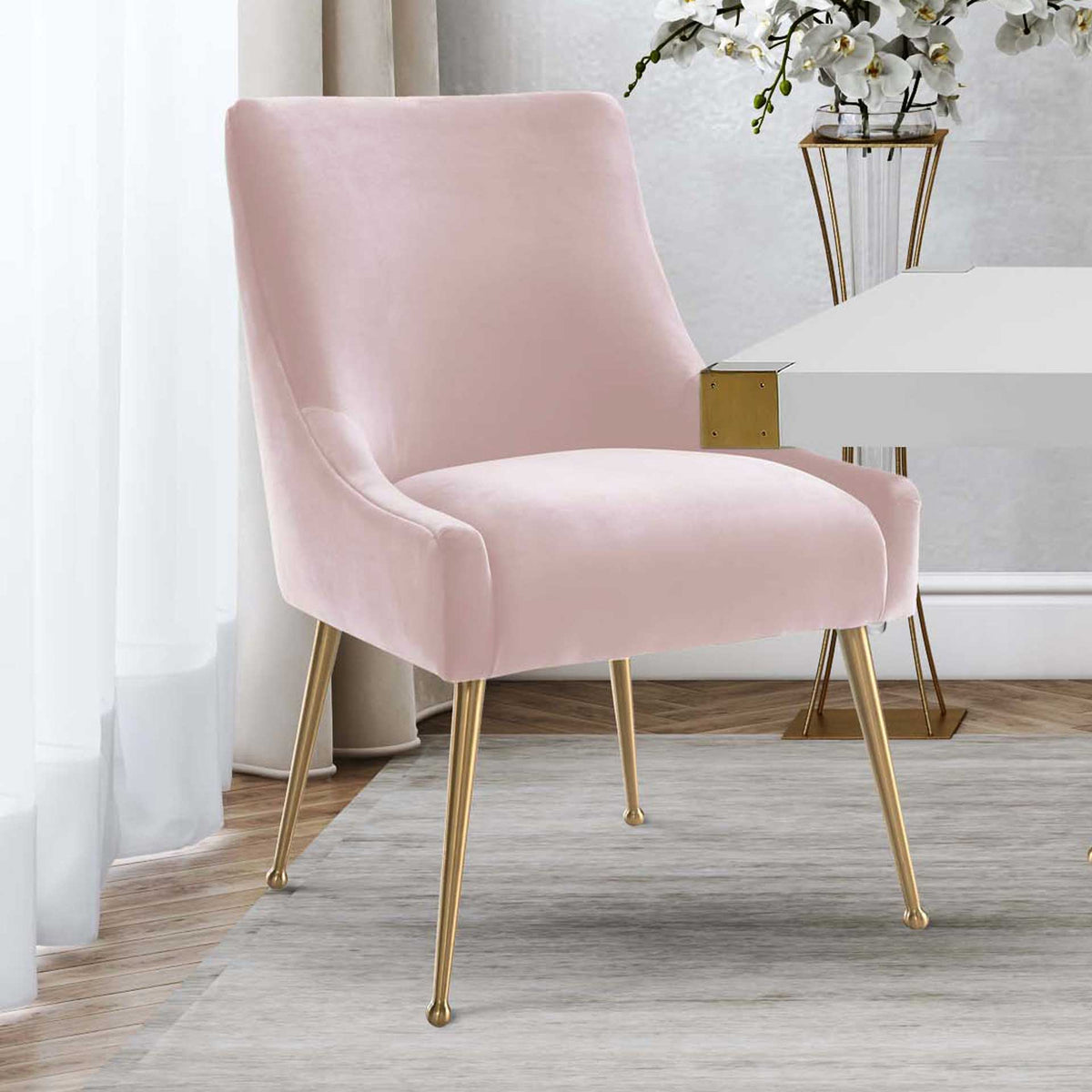 Blush velvet and slender gold legs lend a soft, elegant contrast to a crisp white dining table.