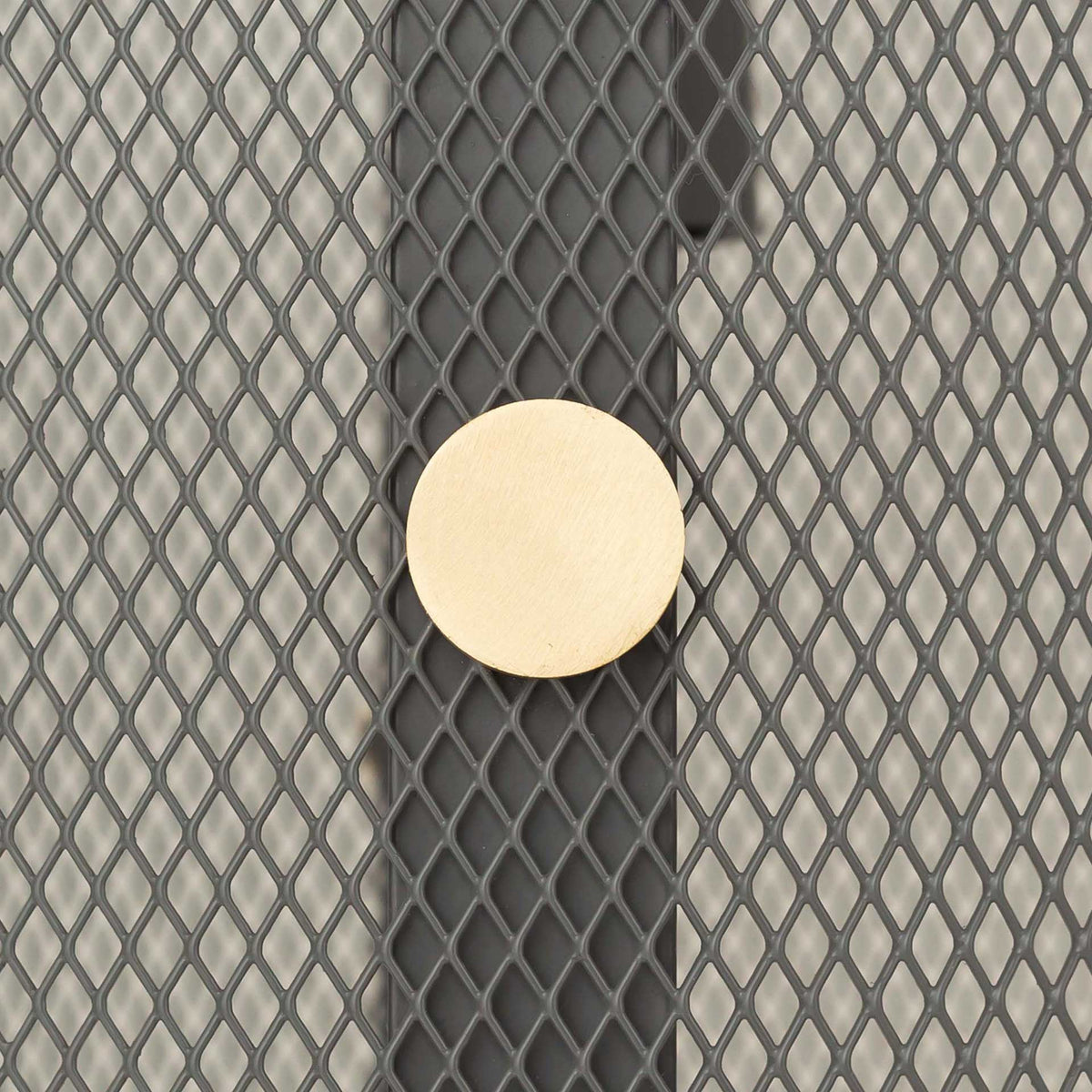 A round brass accent adds a warm metallic contrast to the gray diamond-patterned mesh