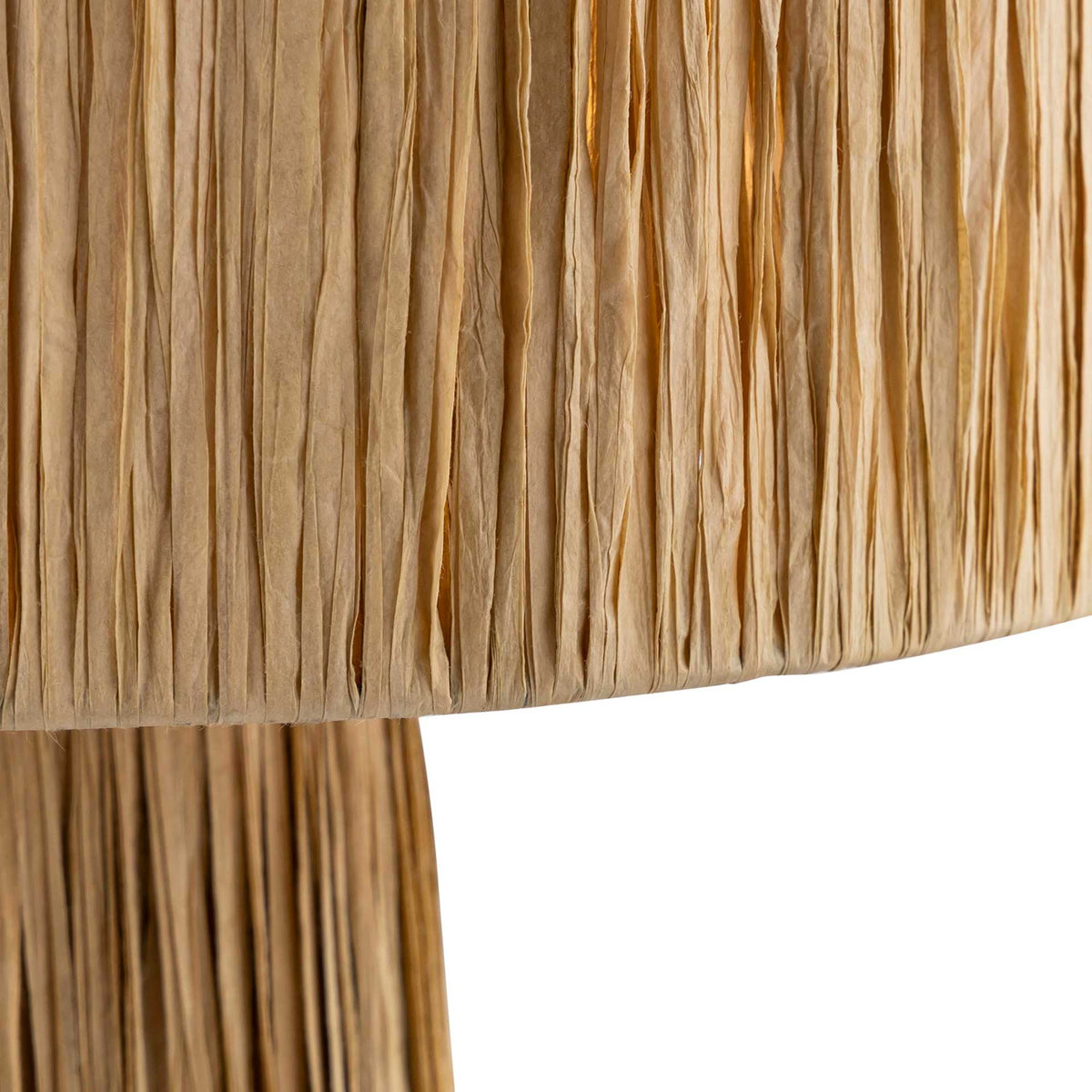 Layered natural raffia strands give the drum shade an inviting, tactile texture