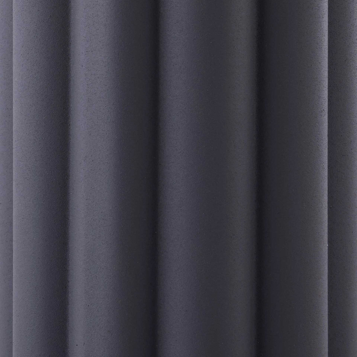 Rounded gray iron flutes add architectural texture to the lamp's sculpted base.