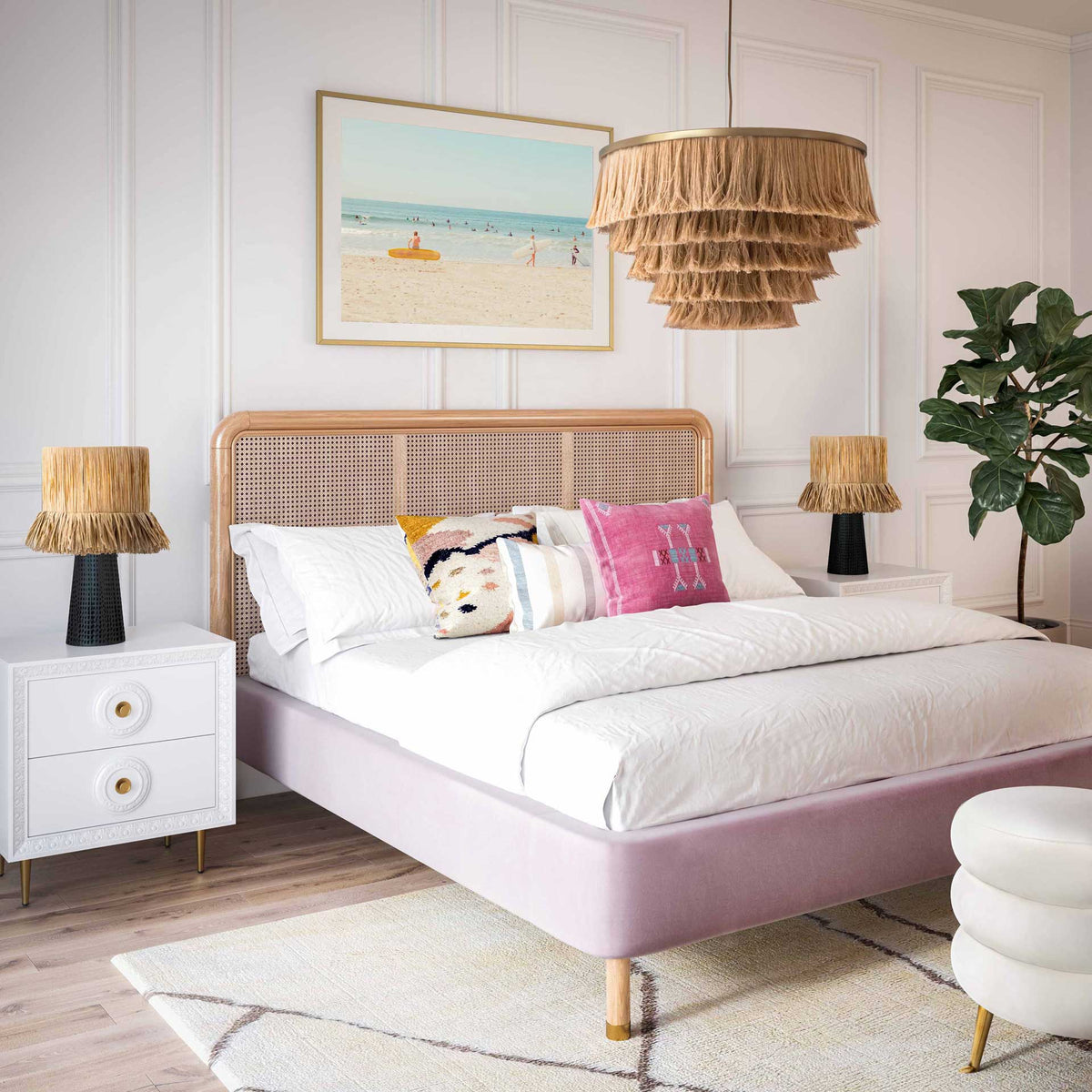 Layered natural fringe and brass-finished accents add relaxed texture above a cozy bedroom retreat.