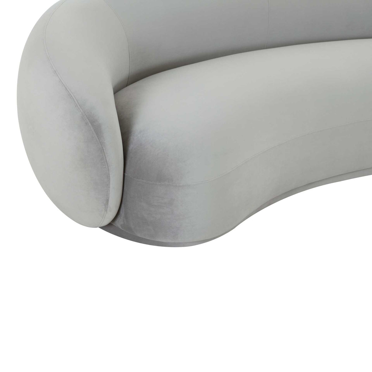 Plush light gray velvet softens the sculpted arm and gently curved seat edge