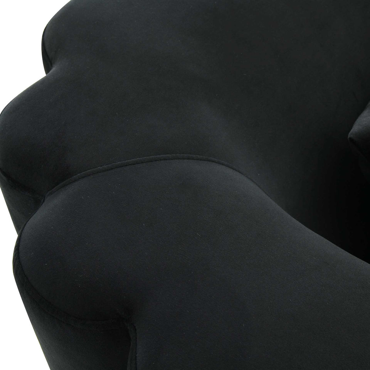 Soft black velvet and flowing seams accent the sofa's rounded, padded curves