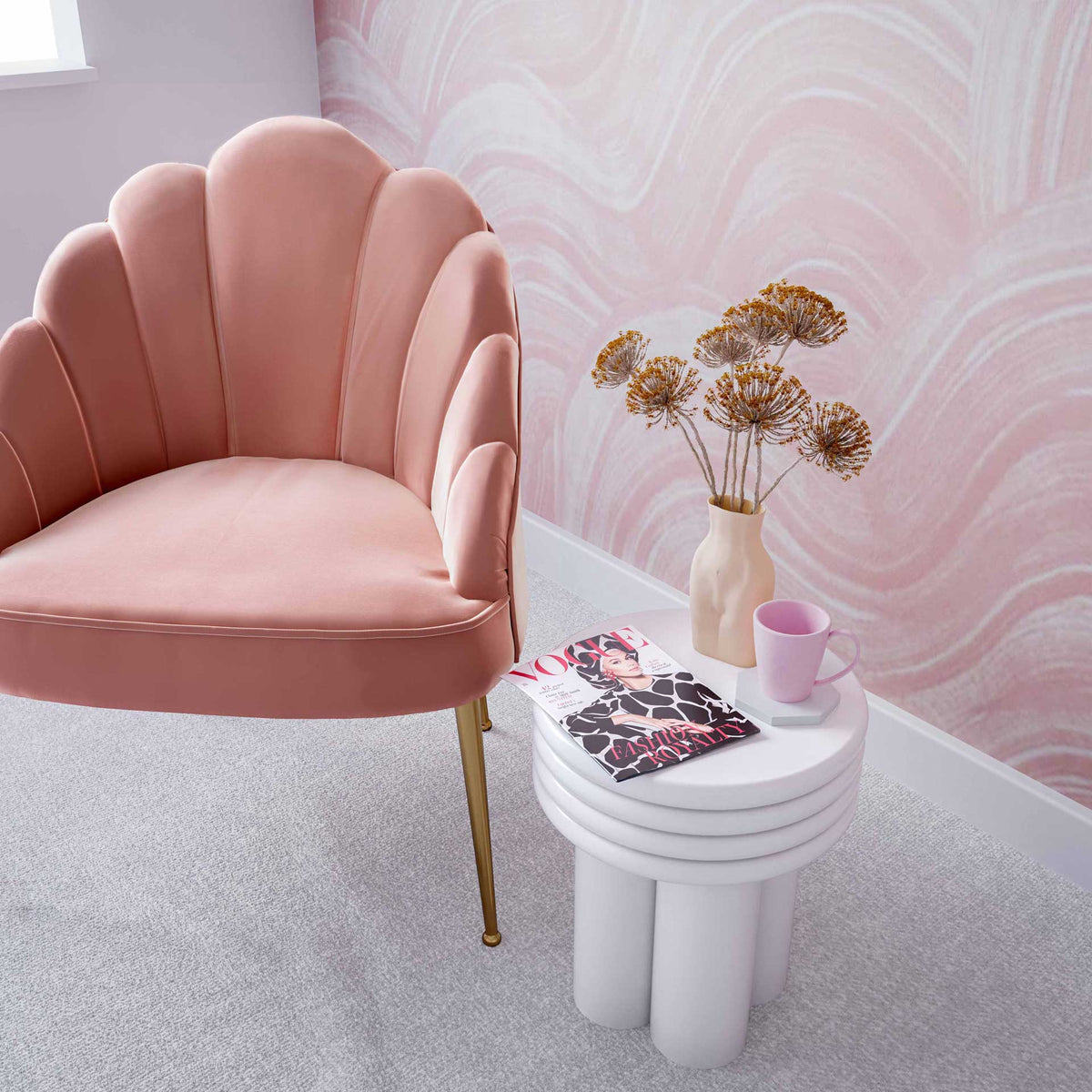 A compact ivory side table offers a stylish spot for a magazine, mug, and decorative vase