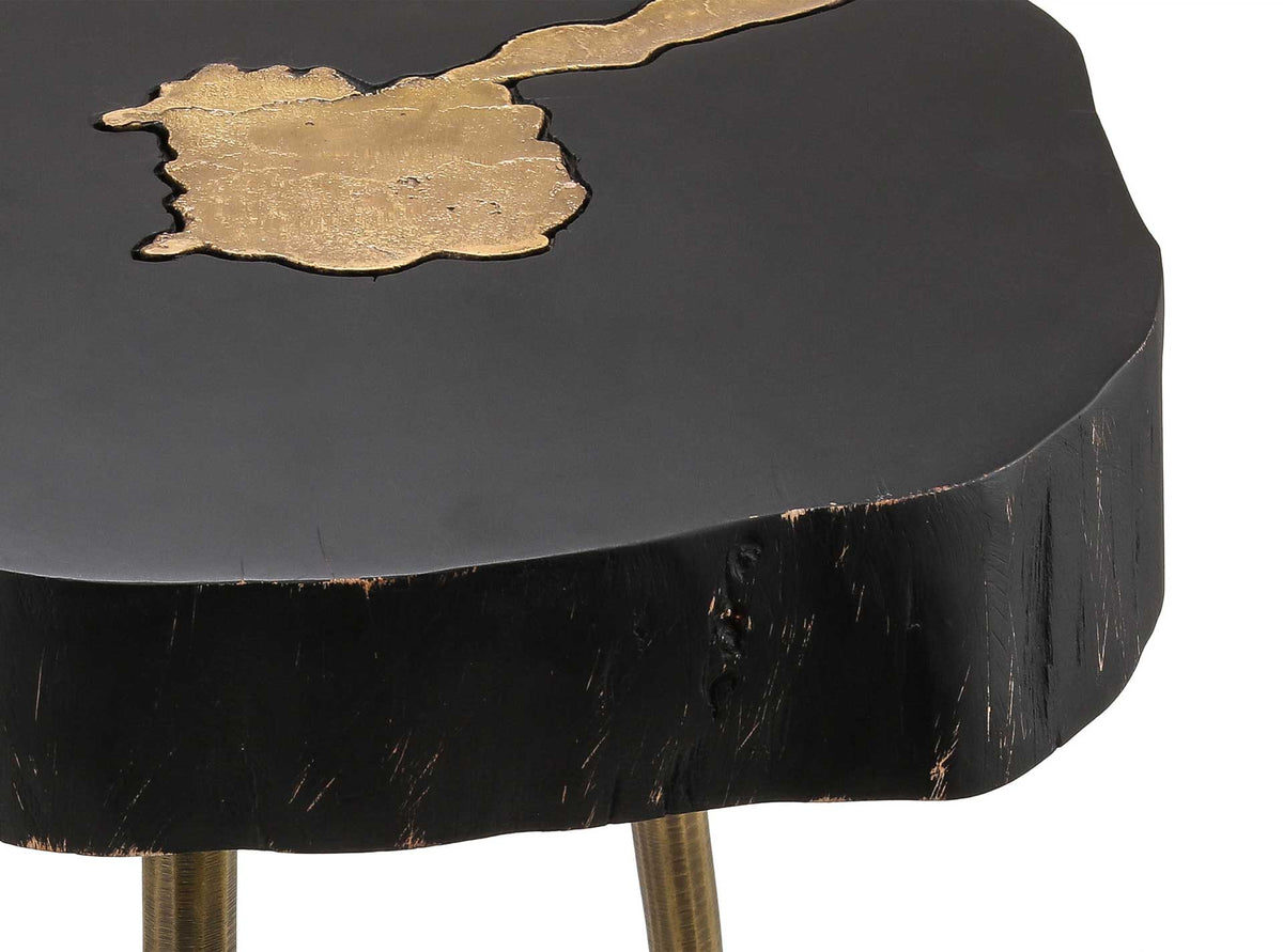 Shimmering brass fills a natural knot in the smooth black tabletop above its rugged wood edge