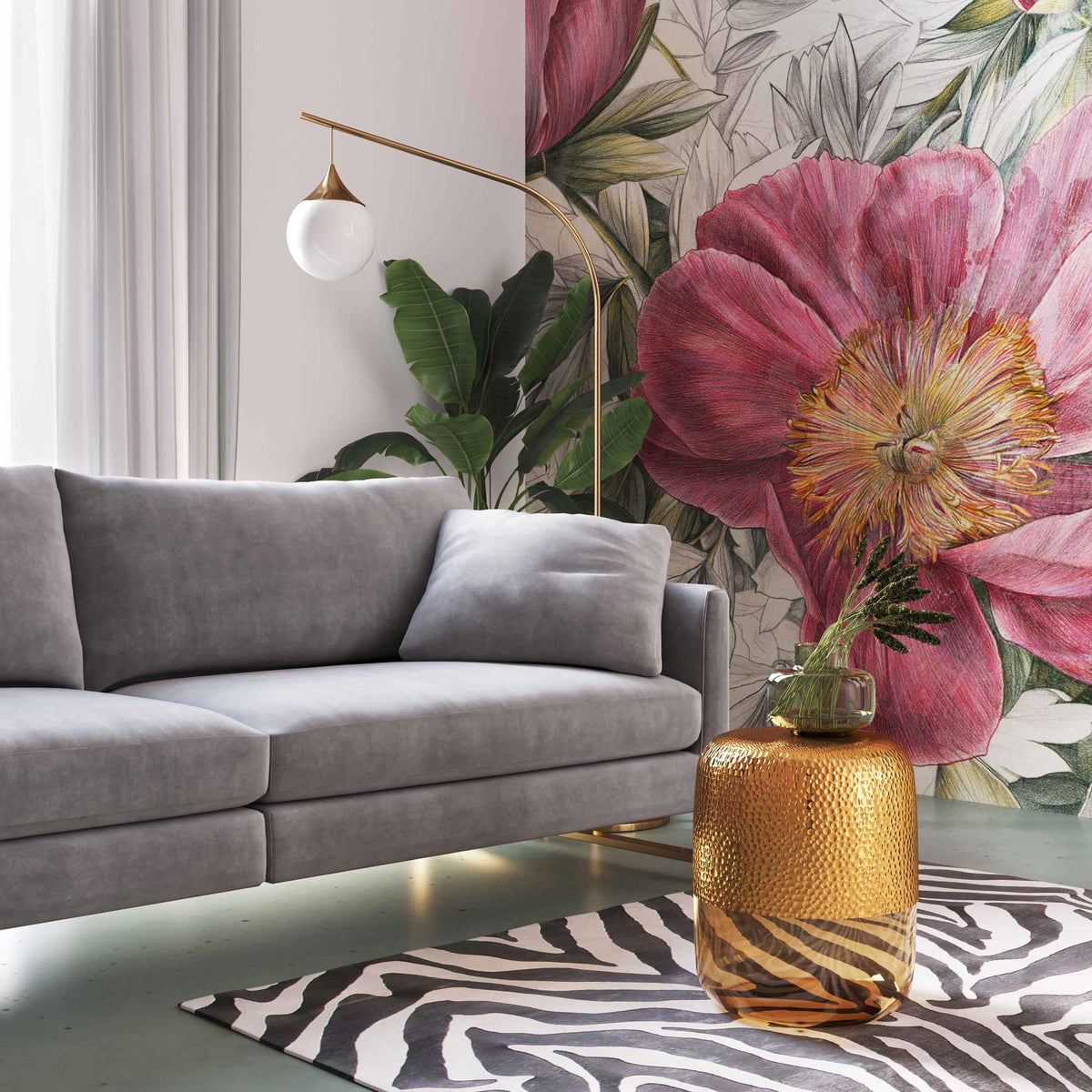 A gold-finished top and amber glass base bring warm shimmer beside a gray sofa and a boldly patterned rug.