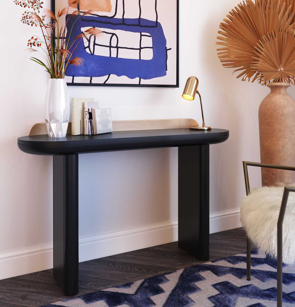 A sleek black console with warm brass-finished trim makes an elegant spot for books and decor