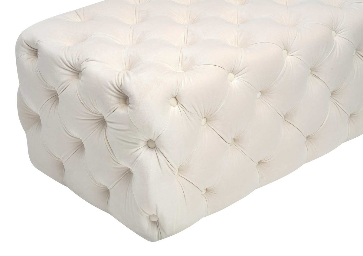Gathered cream velvet and inset buttons create rich texture around the ottoman's cushioned corners.