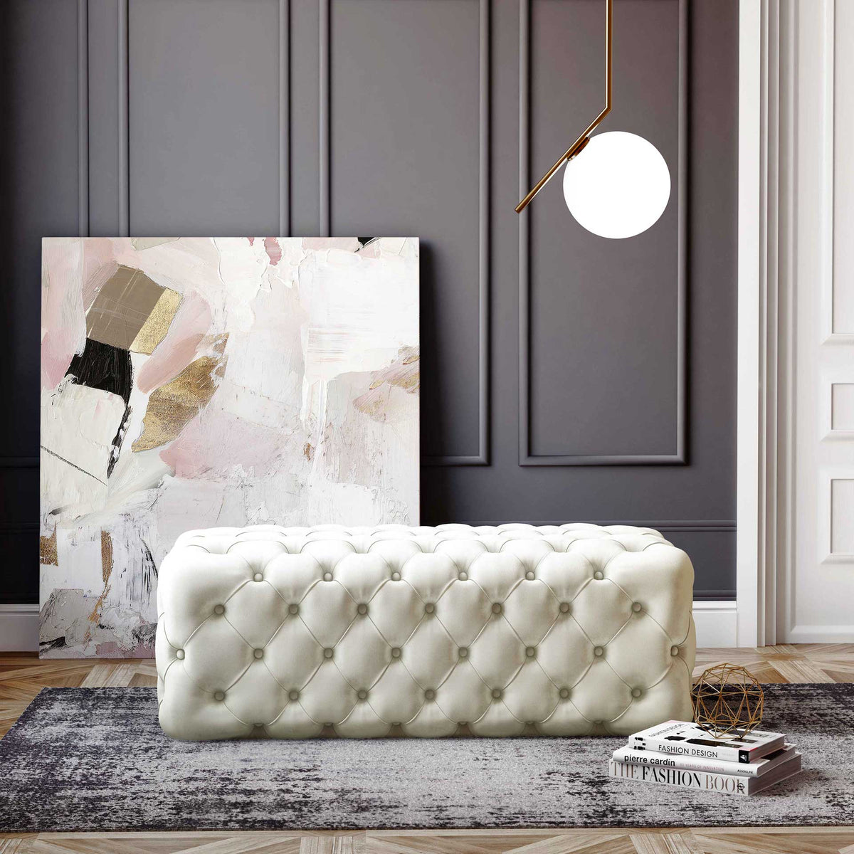 A low-profile cream velvet ottoman adds a soft, tufted accent to a sophisticated living space.