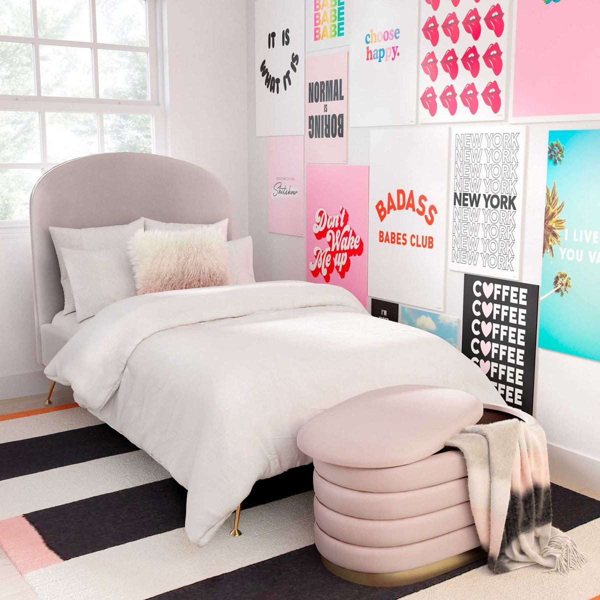 A rounded blush velvet bench brings cushioned seating, hidden storage, and gold-tone shine to the bedroom