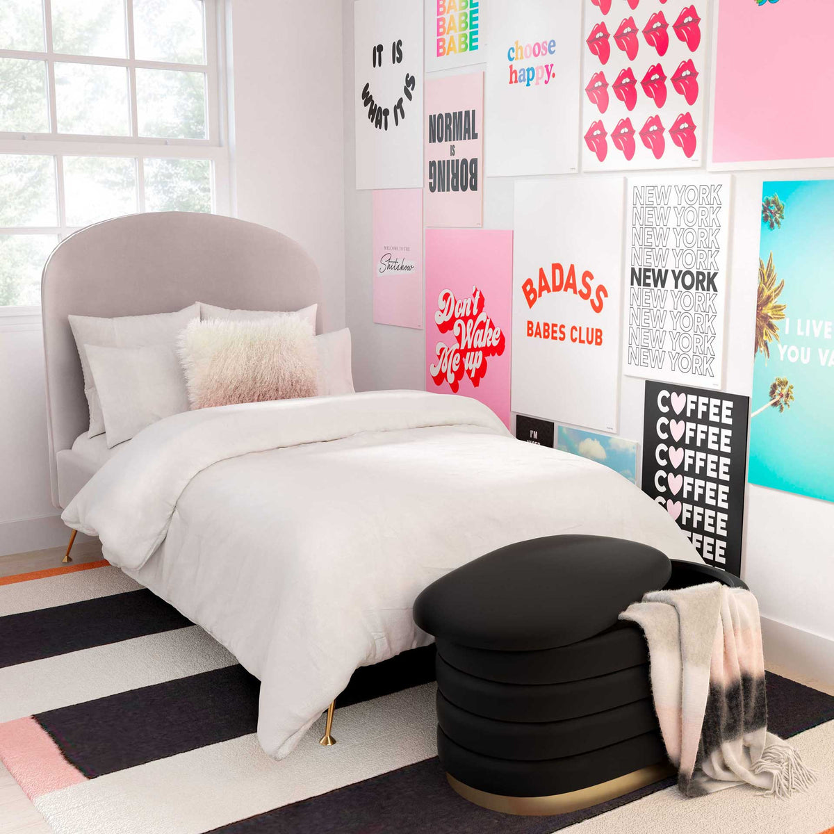 A plush black velvet storage bench adds chic seating and hidden storage at the foot of the bed
