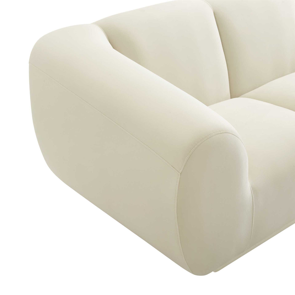 A rounded arm with neat stitching highlights the sofa's soft cream velvet upholstery