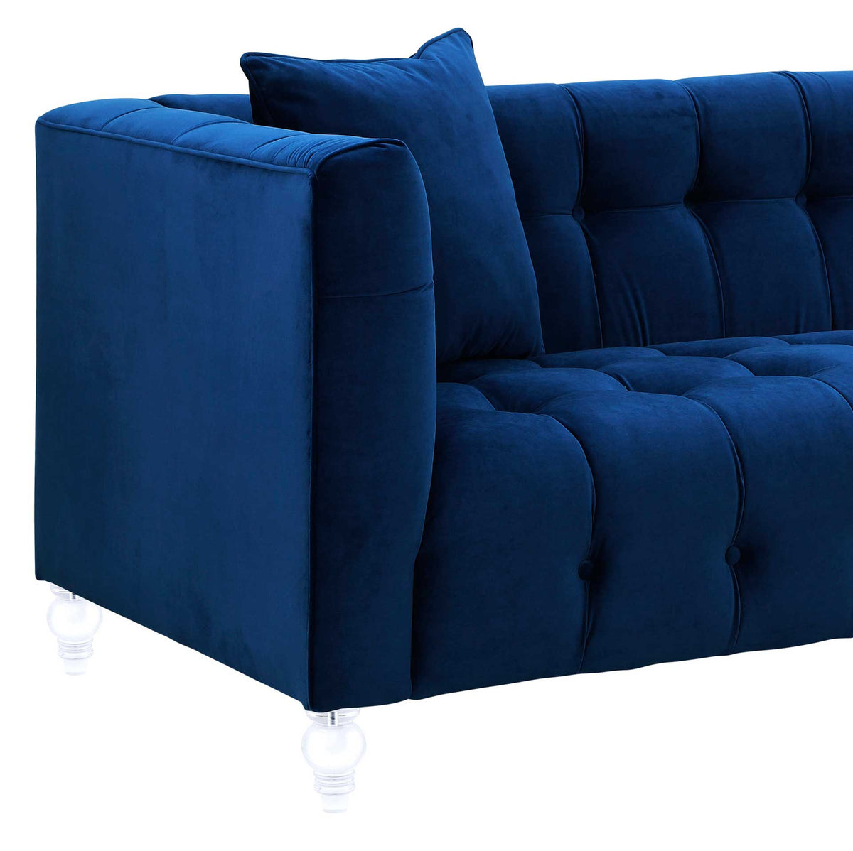 Deep blue velvet highlights a padded square arm, plush button tufting, and a clear turned leg