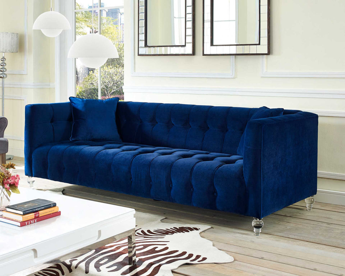 Vibrant navy velvet, enveloping arms, and plush tufting create a bold, inviting place to unwind