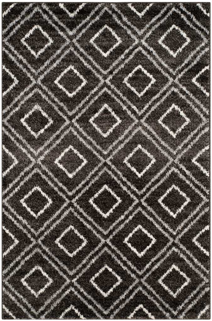 A cozy anthracite rug pairs fine cream lines with repeating geometric diamonds.
