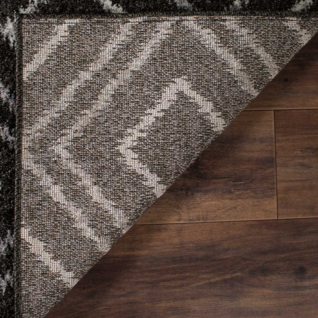 A woven jute backing supports the dark rug's soft, cream-patterned pile.