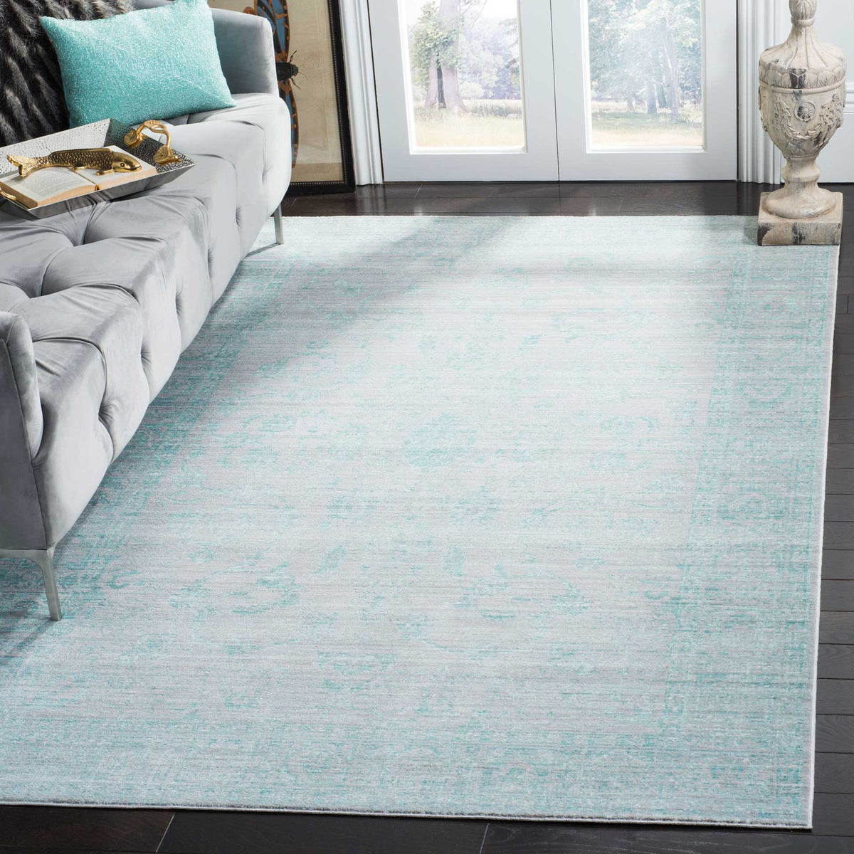 A softly faded aqua rug brings airy color and vintage character to a bright living space
