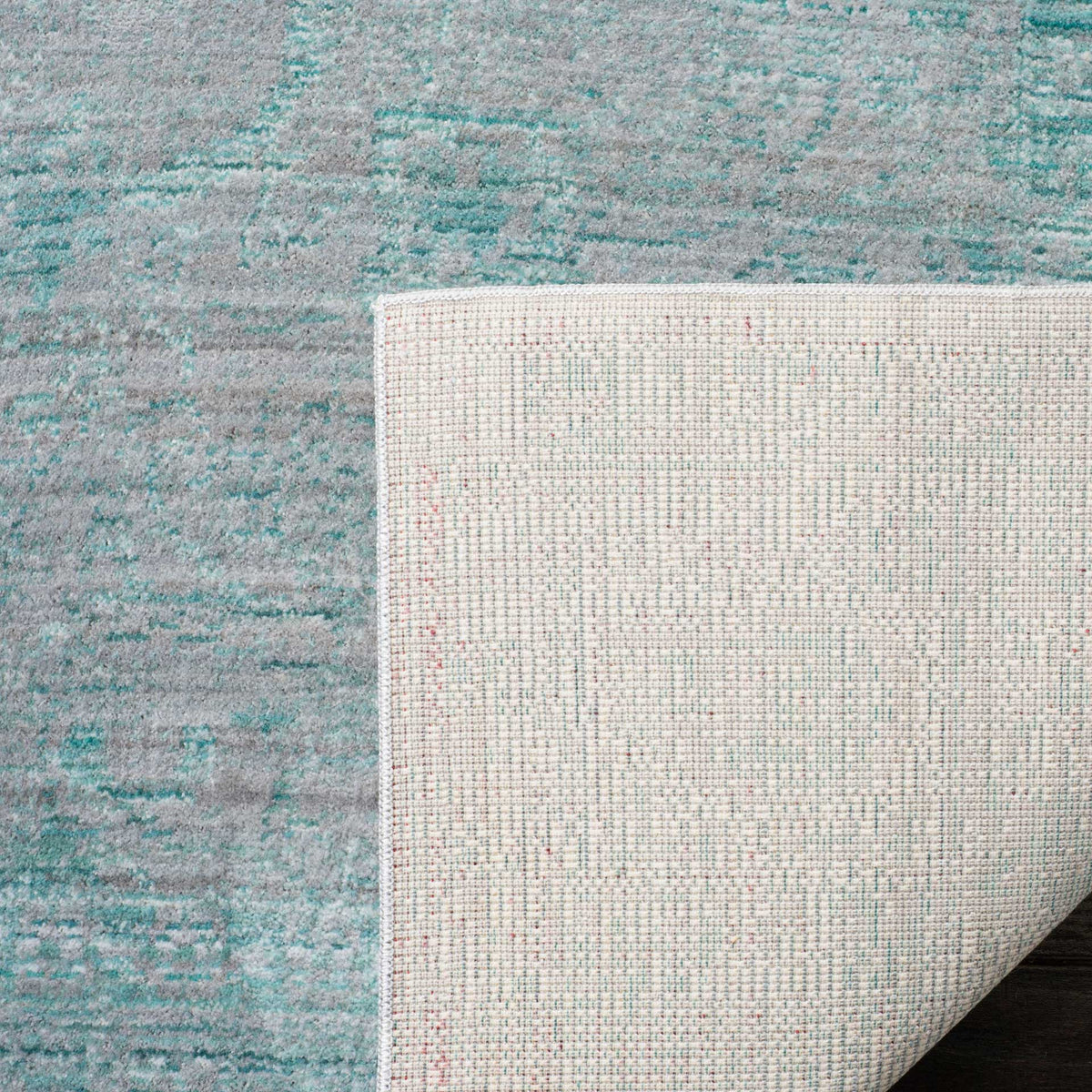 Woven cotton backing adds structure beneath the rug's distressed blue surface