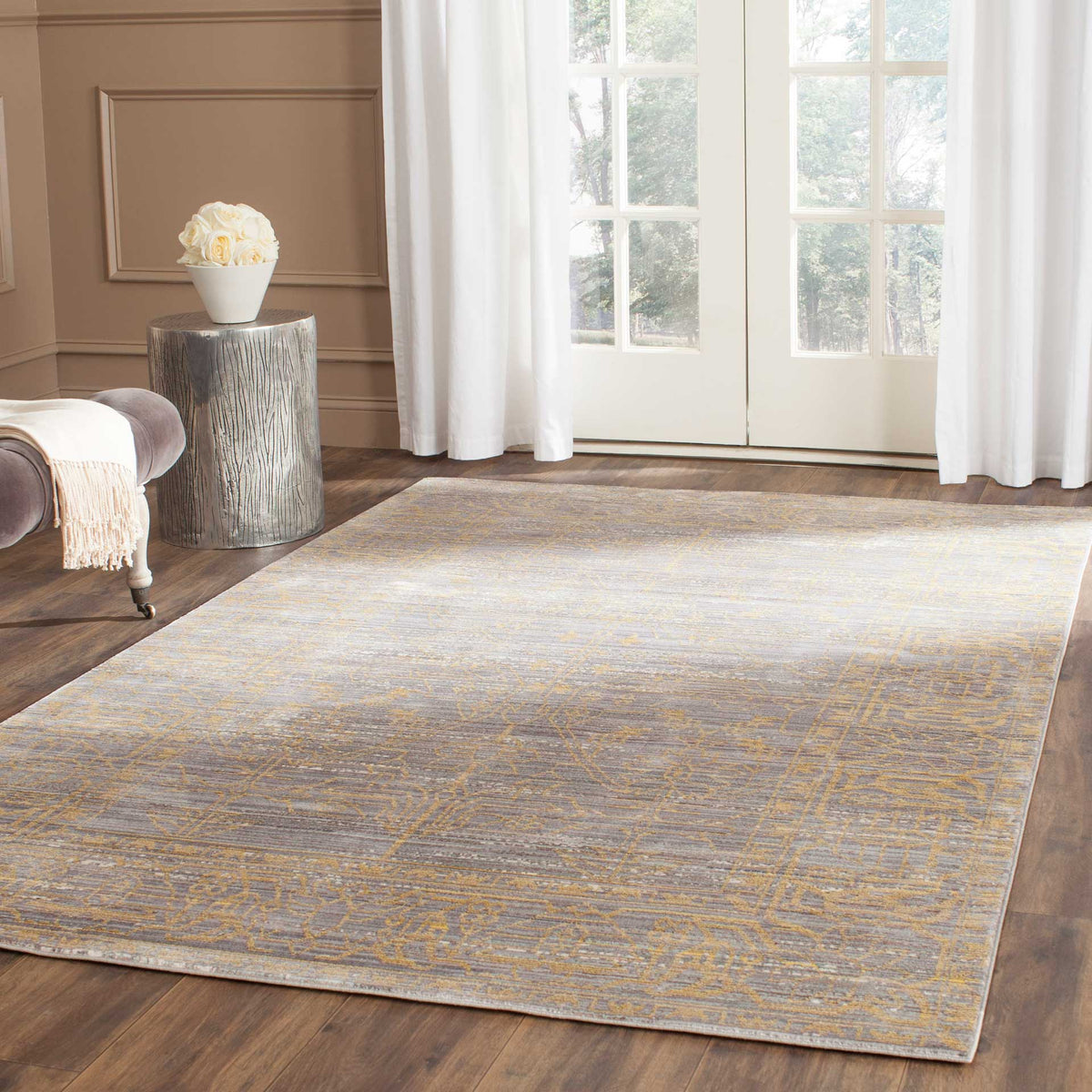 Gray and gold rug adds a softly faded, ornate pattern to a bright living space