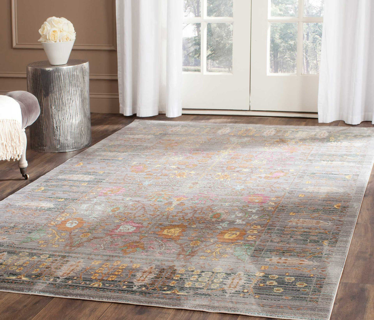 A softly distressed gray rug brings colorful floral patterning to a bright living space.