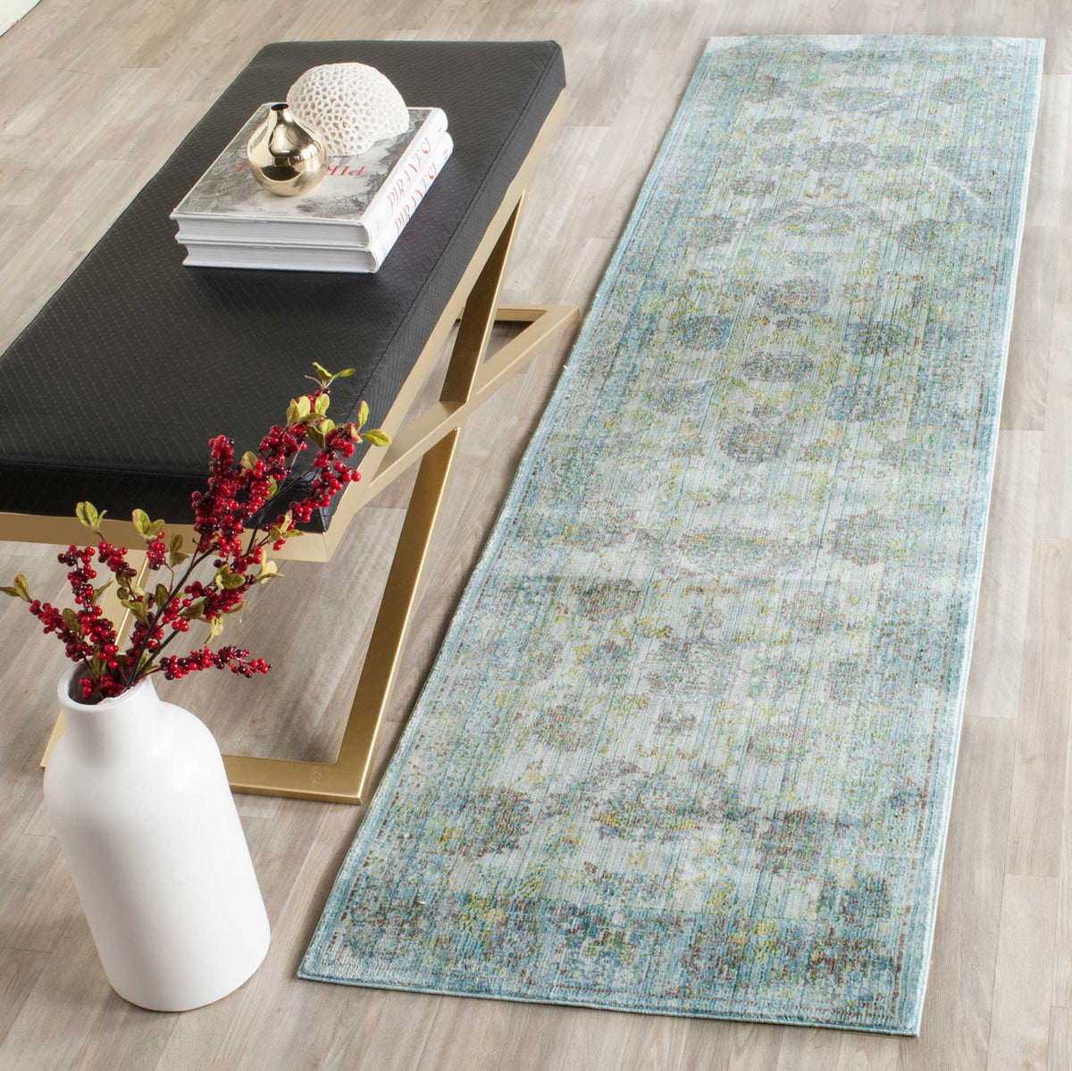An airy blue and turquoise runner adds softly distressed pattern beside a modern bench