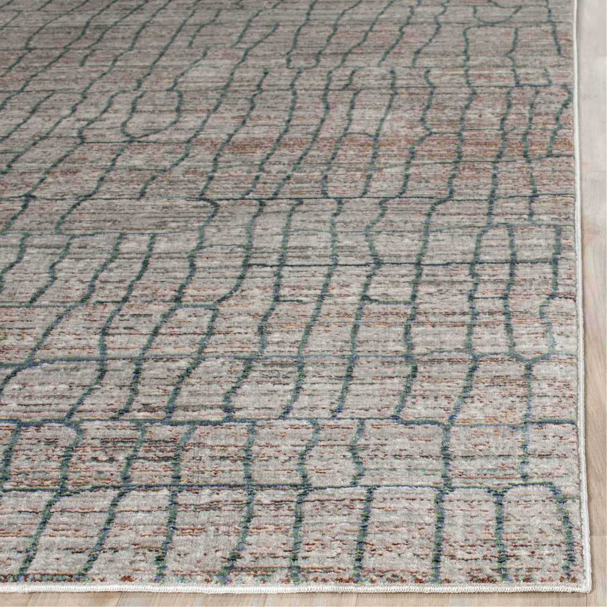 Subtle warm flecks and blue-lined shapes meet a neatly bound edge on this textured gray rug