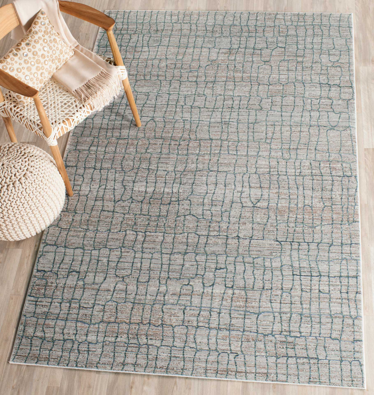 A soft gray rug with flowing blue grid lines adds gentle pattern beneath a cozy chair
