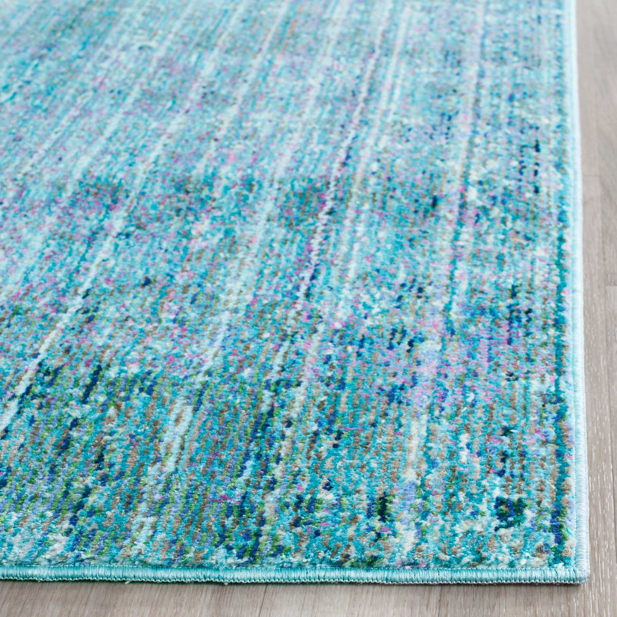 Low-pile turquoise fibers show intricate blue flecks and neatly bound edges