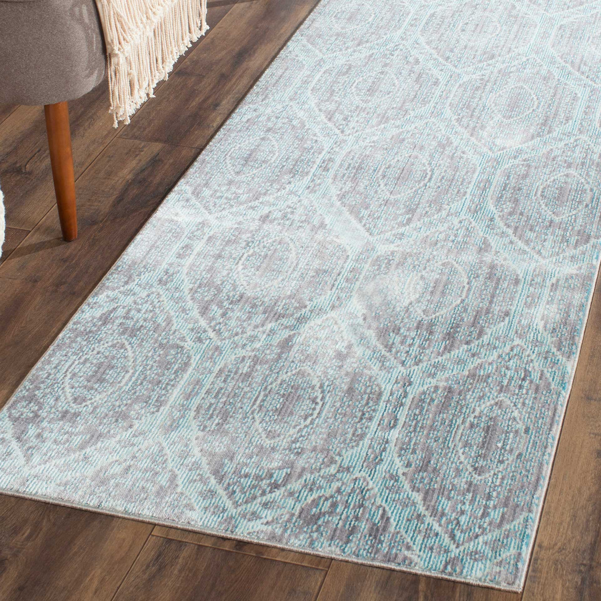A low-profile runner adds vintage-inspired mauve and aqua pattern to a dark wood floor.