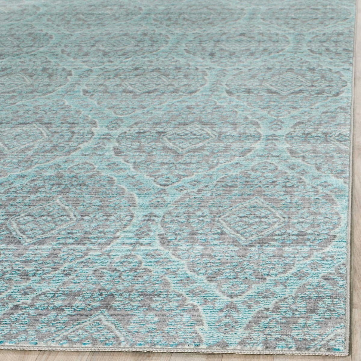 Soft aqua and mauve medallions meet a neatly bound edge on this low-profile rug.
